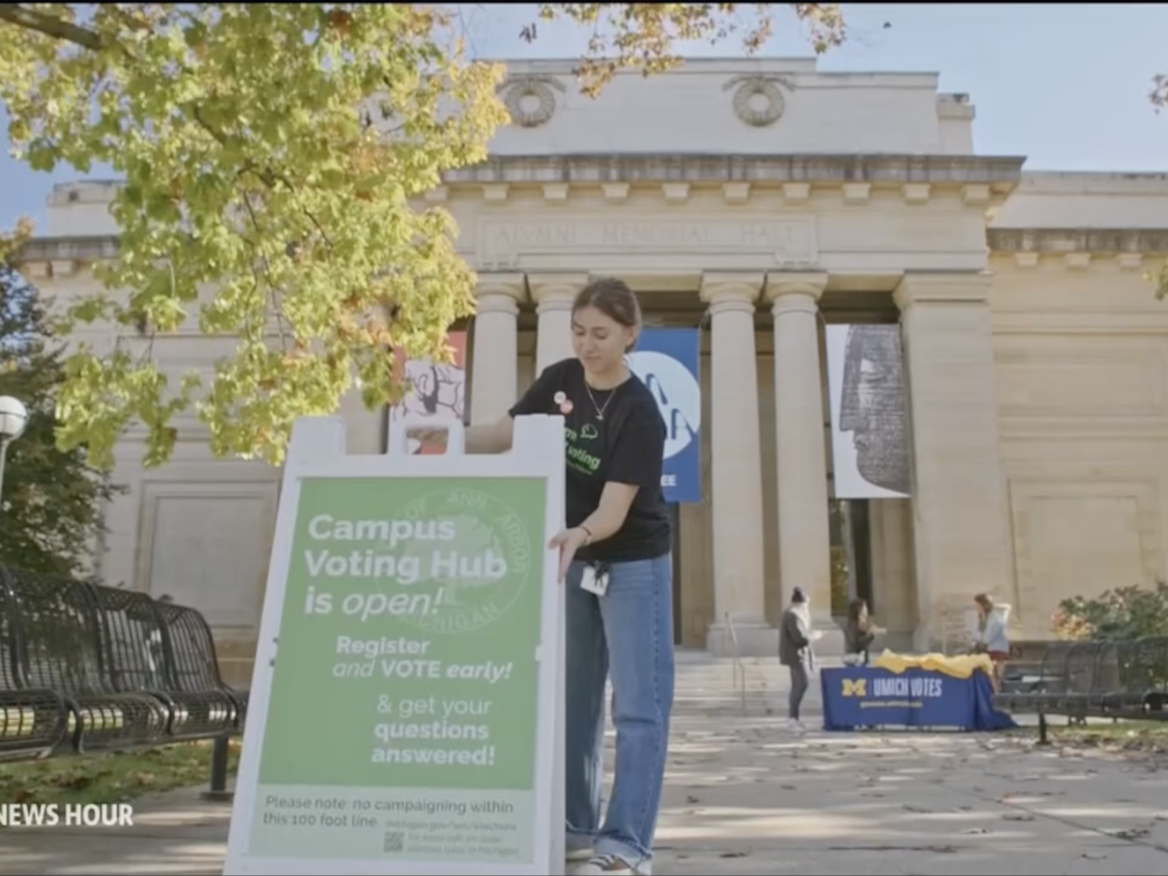 girl setting up a voting sign